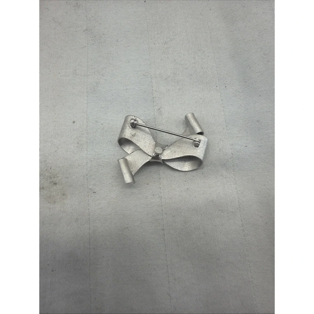 sterling silver bow brooch with a brushed, textured finish